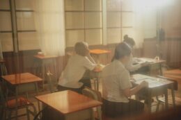 Students sitting at desk in classroom.