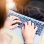 close up of student's hand on laptop